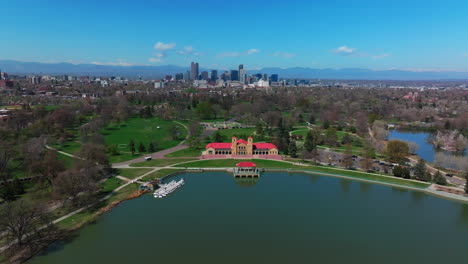 city park denver colorado lake pavilion vibrant blossom spring summer aerial drone sunny blue sky snow capped rocky mountains front range cityscape green lush grass trees forward upwards motion