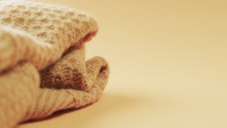 Micro-video-of-close-up-of-yellow-wooly-crochet-fabric-with-copy-space-on-yellow-background