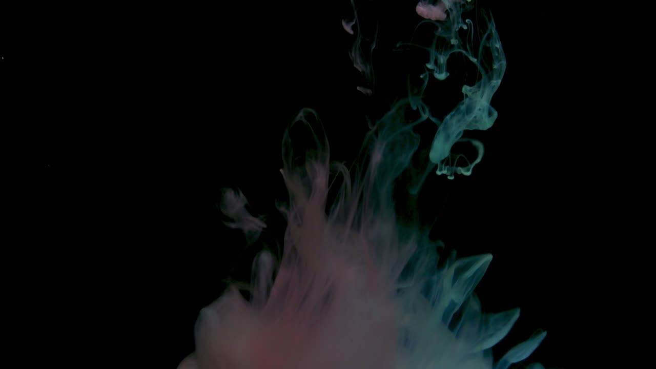 gotas de pintura rojas y azules de colores mezclándose en el agua. tinta girando bajo el agua. nube de acrílico de colores explosión de humo abstracto. vista de cerca