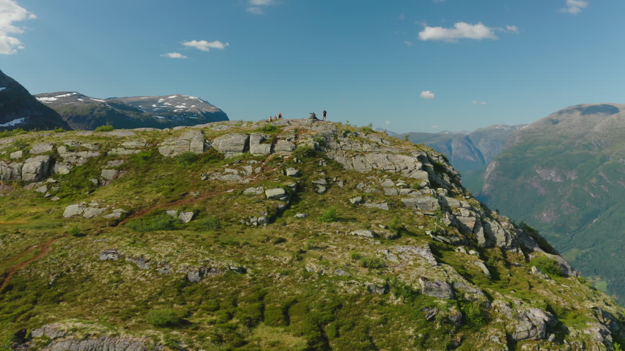 Turister ved klippetoppen af Olden landsby med udsigt over Oldeelva-floden i Vestland fylke, Norge