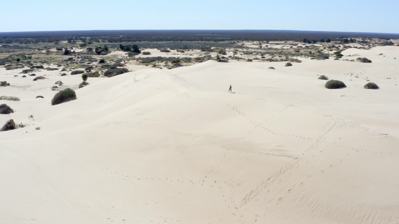 niña explorando enormes dunas de arena en un desierto australiano en un día caluroso y soleado, toma aérea 2
