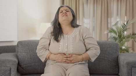 sick indian old woman suffering from stomach pain