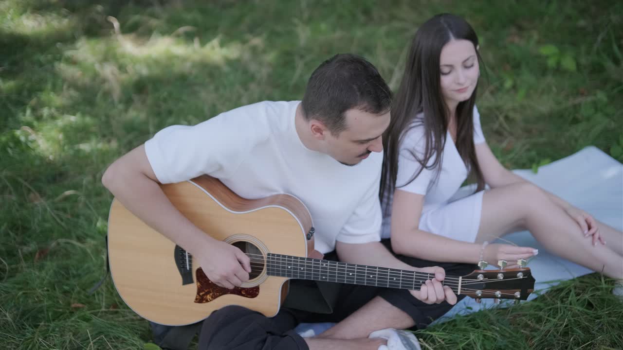 A couple relaxing and playing guitar outdoors