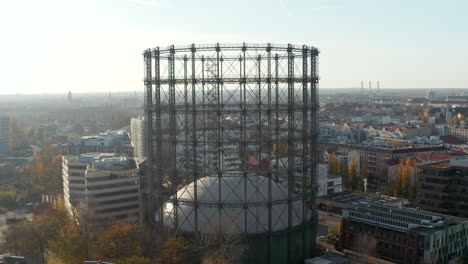 Vista-Escénica-De-La-Estructura-Metálica-Del-Gasómetro-En-Medio-De-La-Ciudad,-Carro-Aéreo-Lento-En-Berlín,-Alemania