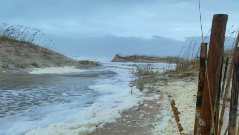 flood waters from aftermath of hurricane storm surge on beach, pov