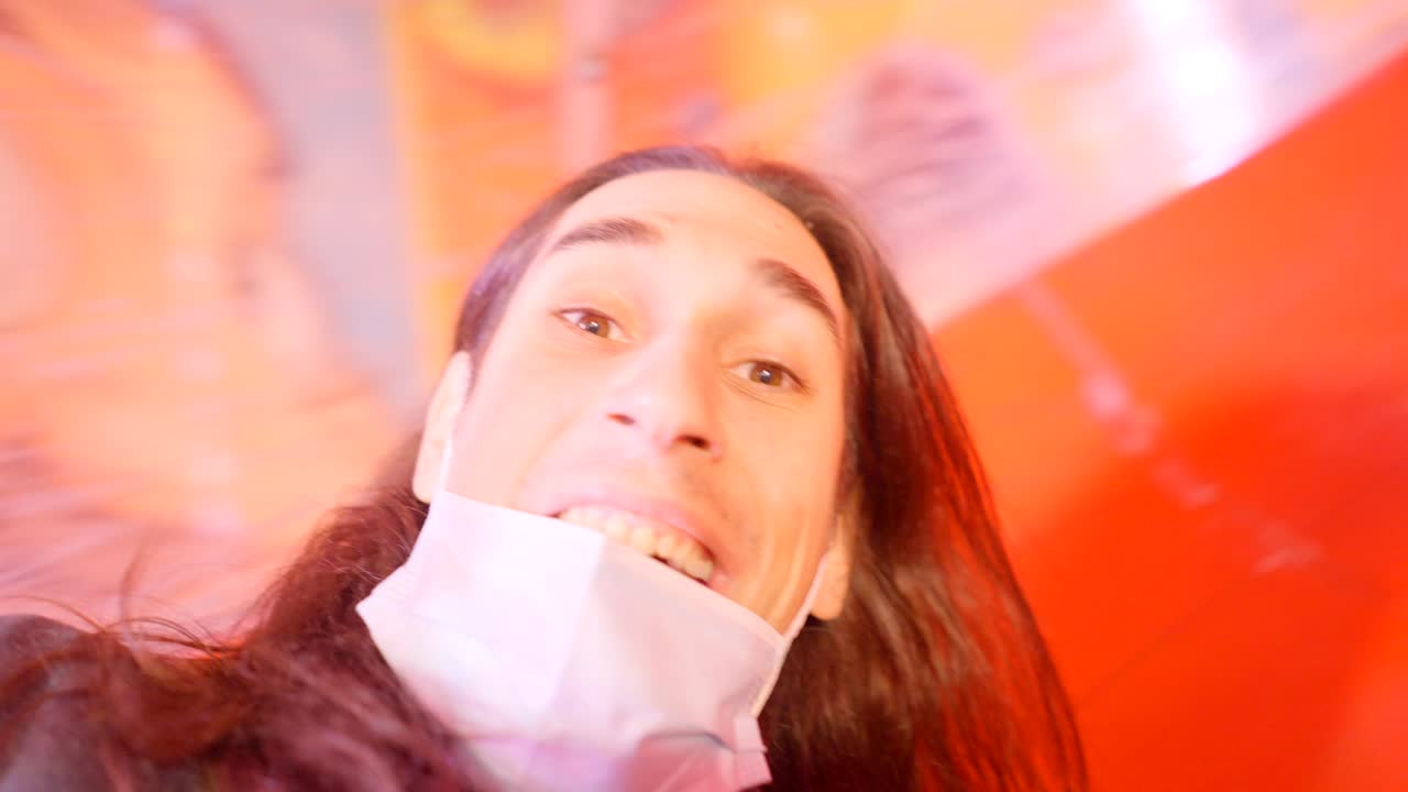 Man with mask inside a colorful tunnel