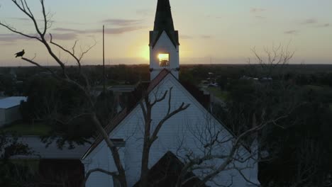 small church with steeple and approaching sunrise