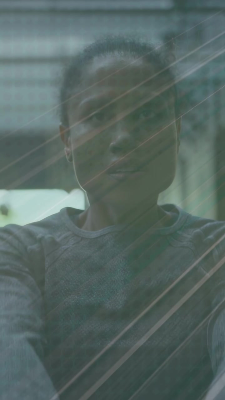Vertical video: Female behind glass raising cup streaks shifting hiding then revealing face for ads