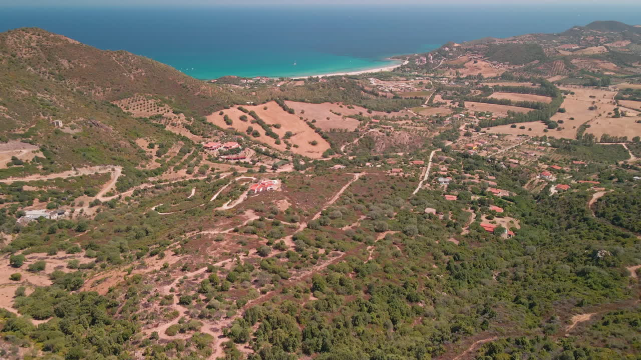 impresionante paisaje rural con vegetación verde y caminos de tierra, hermoso mar azul al fondo en cerdeña, italia - toma panorámica aérea