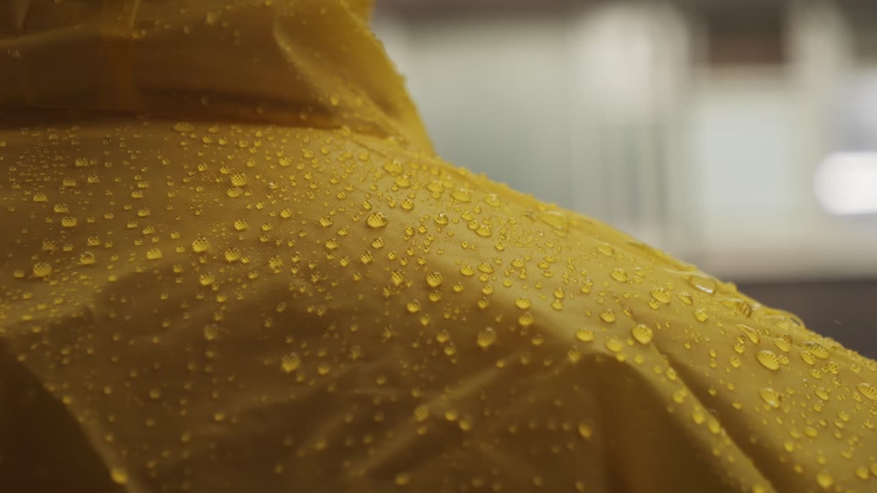 Business man tourist person with umbrella and raincoat on rainy european city street, lights reflecting, walking in Barcelona or Amsterdam during the rain