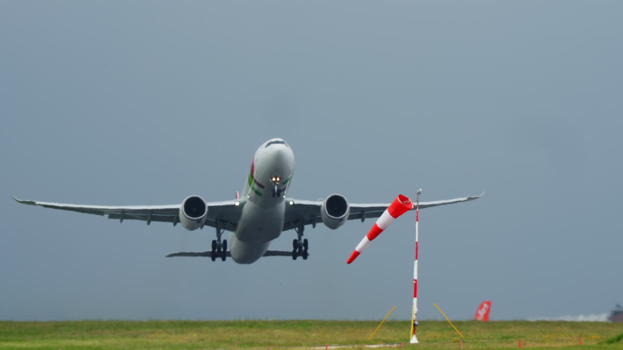 Decollo di un wide-body TAP Air Portugal con manica a vento all'aeroporto di Lisbona