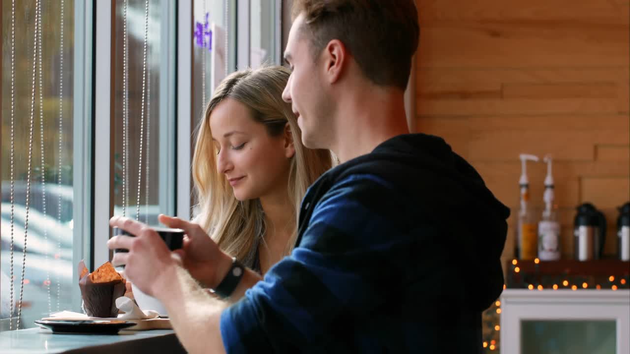 Young romantic couple interacting with each other in cafe 4k