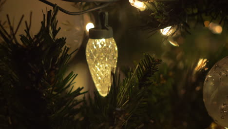 una diapositiva de primer plano en las luces y adornos del árbol de navidad, bokeh, enfoque selectivo, macro, de izquierda a derecha