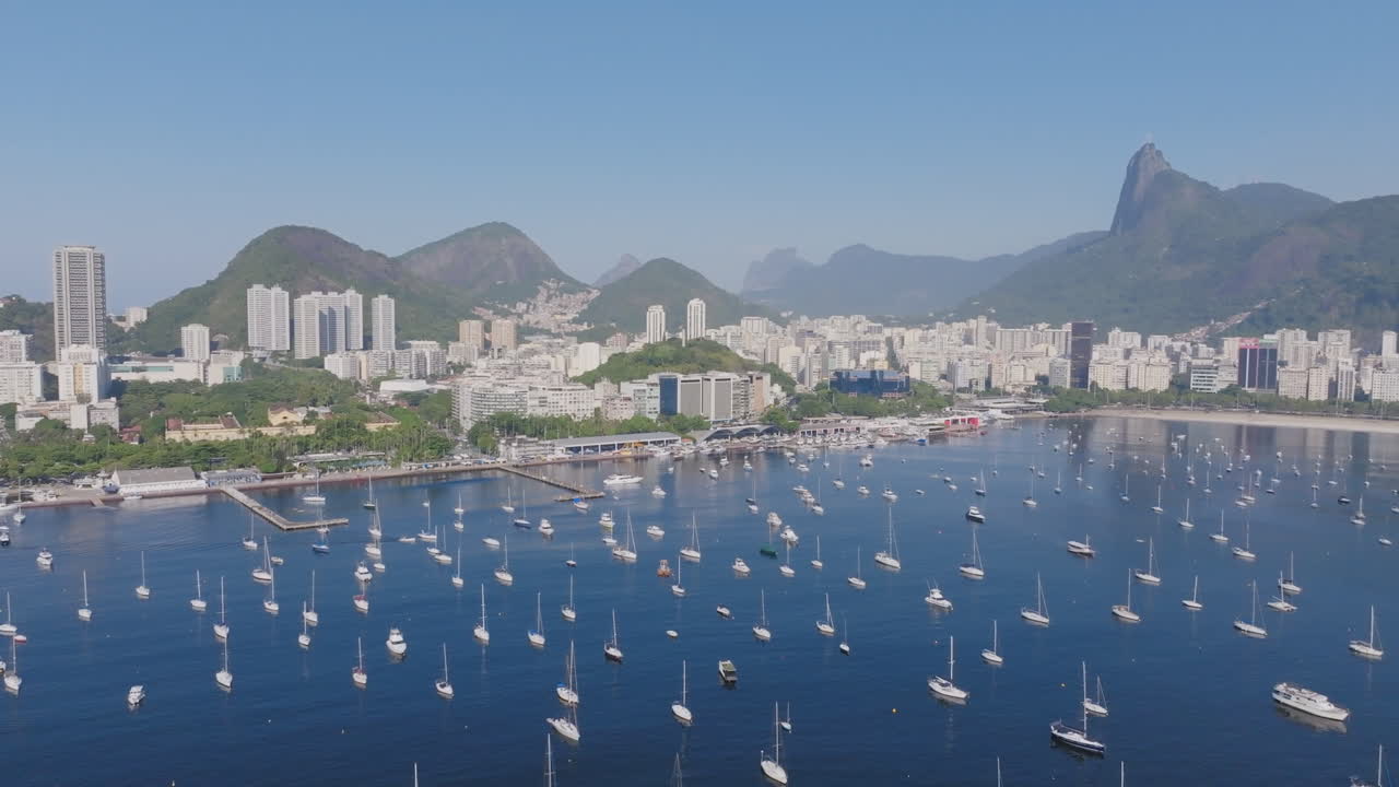 브라질 리오데자네이로 (rio de janeiro) 의 도시를 배경으로 보타포고 만 (botafogo bay) 에 고정된 선박의 공중 비행