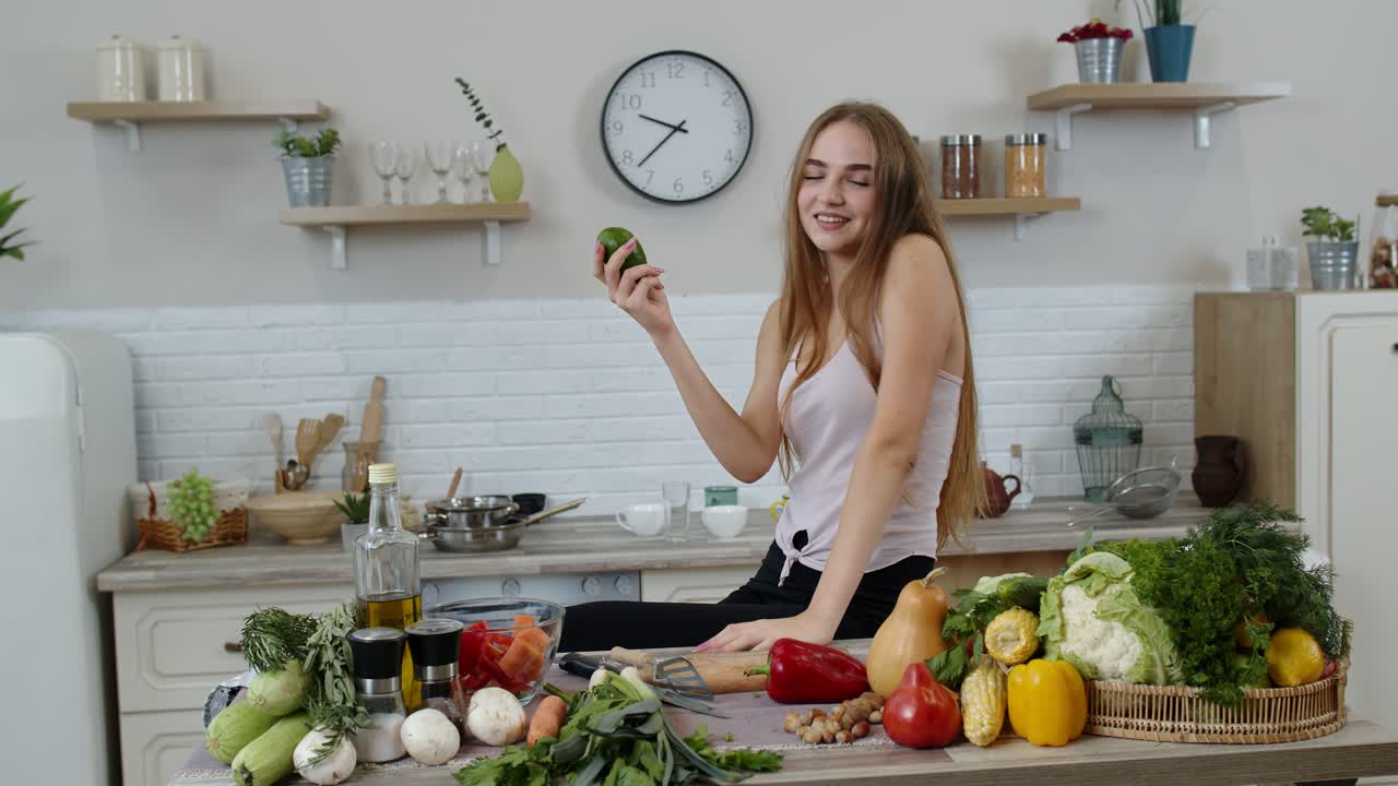 chica recomendando comer alimentos vegetales crudos. mostrando aguacate en las manos. pérdida de peso y concepto de dieta