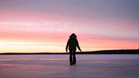 person on a frozen lake at sunset