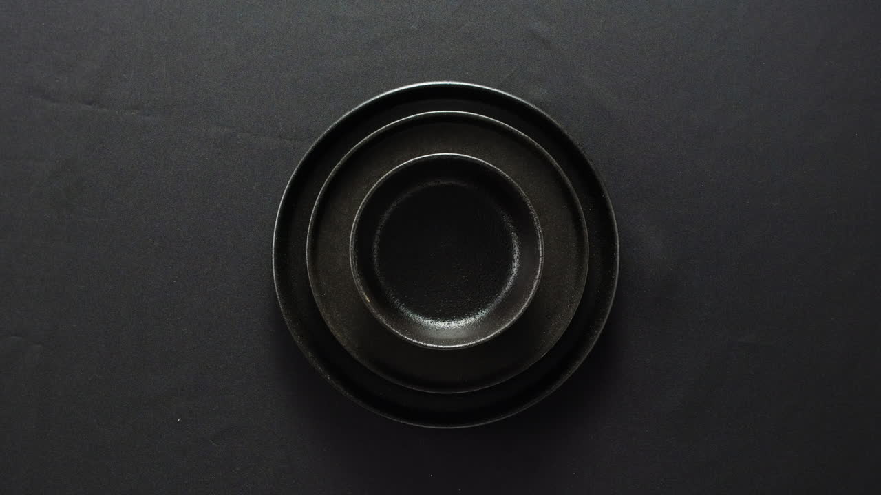 Professional table setting with white gloves. Plates, fork, knife, and glass arranged on a white table.