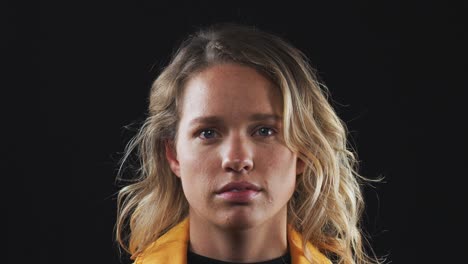 head and shoulders studio shot of unhappy woman looking at camera with sad expression in slow motion