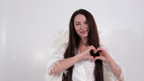 Woman making a heart sign with angel wings