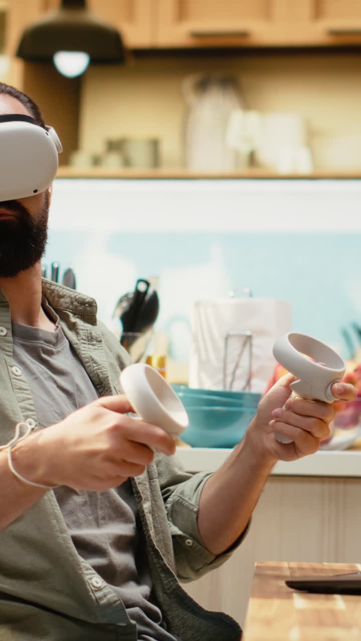 Video verticale: Professionista uomo che usa la tecnologia VR durante il lavoro da remoto al tavolo della cucina