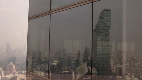 reflection-of-jagged-modern-architecture-of-the-MahaNakhon,-King-power-skyscraper-in-downtown-Bangkok,-the-capital-city-of-Thailand