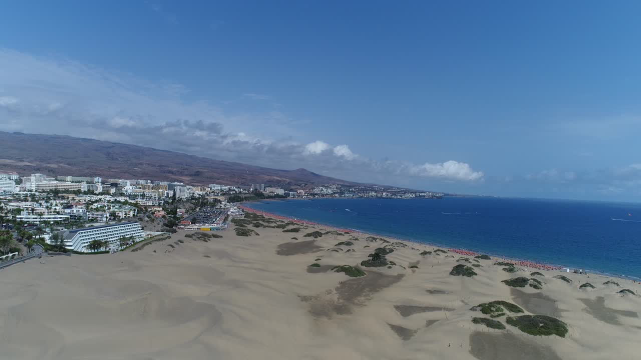 Vista aerea di una città costiera con spiaggia sabbiosa e oceano.