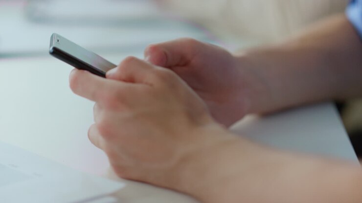 Man hands surfing internet mobile phone. Male person working smartphone indoors