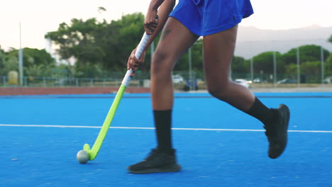 closeup of hockey players using stick to push ball