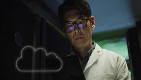 Animation-of-cloud-over-asian-man-working-in-server-room