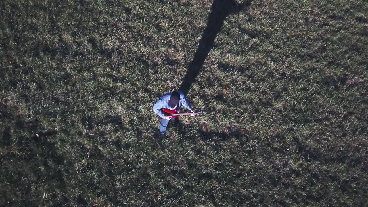 Person Playing Guitar in a Field