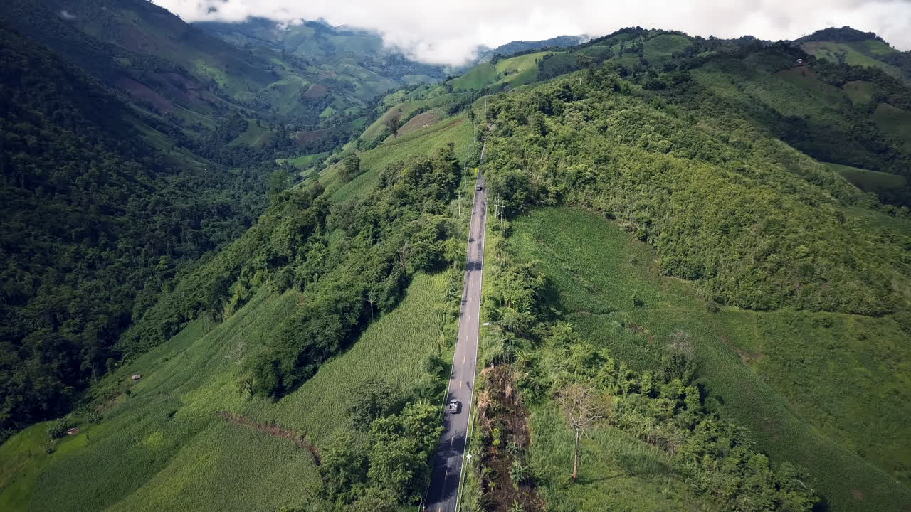 태국 북부 도이푸카산 보호 국립공원의 장마철에 비구름이 덮힌 무성한 녹색 열대 우림 산 위를 날아가는 공중 전망