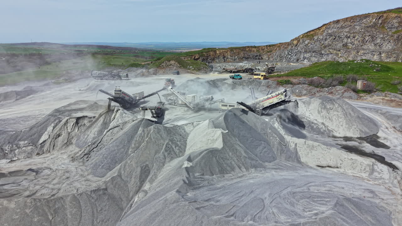 Granite quarry site with machinery working during day providing raw materials for construction projects