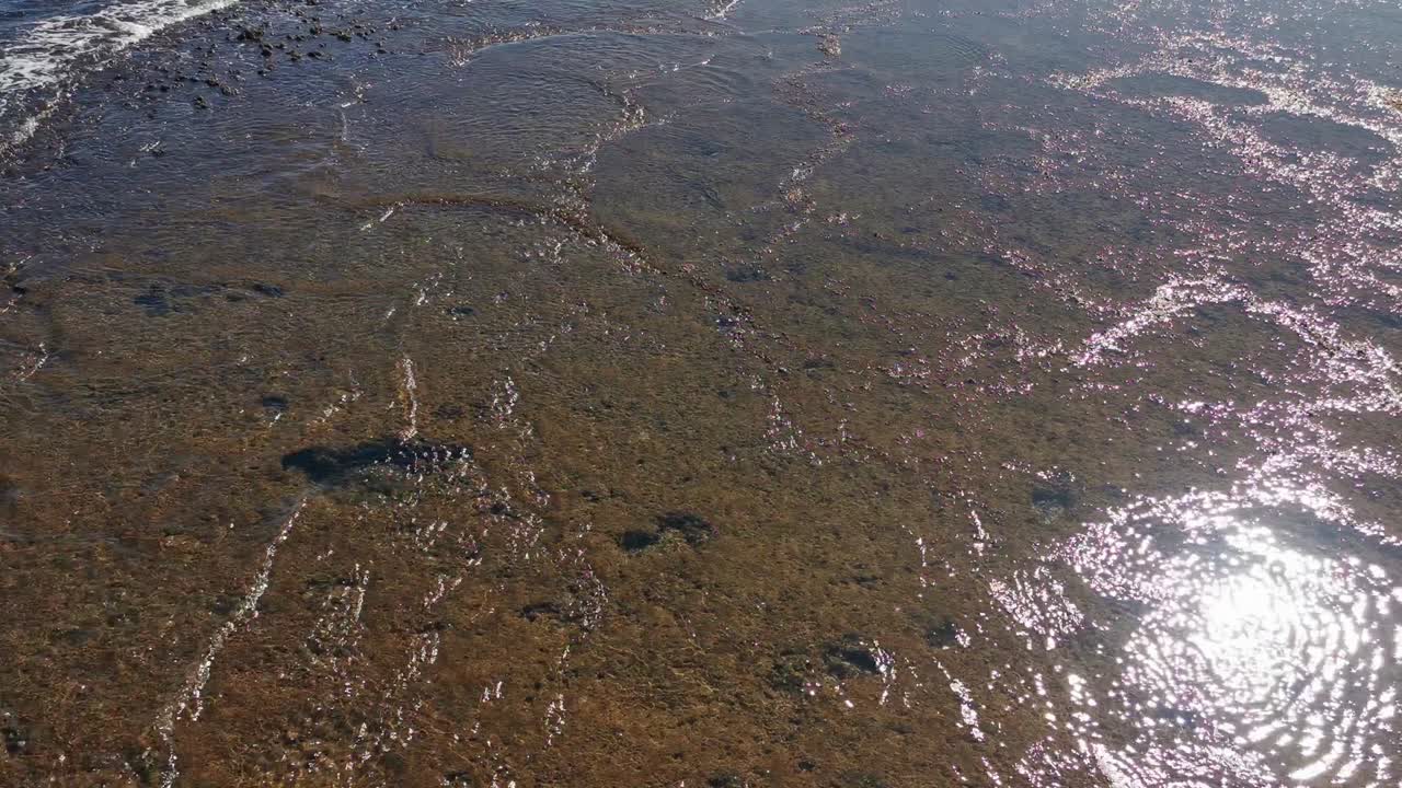 вид морских волн, скал и песка. фон воды на берегу моря