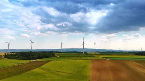 wind turbines stand tall in green fields. wind turbines dot green fields under clouds, highlighting renewable energy in a rural setting