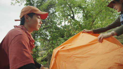 asian female tourists setting up tent
