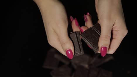 Woman-breaks-black-chocolate-bar.-Close-up.-Slow-motion