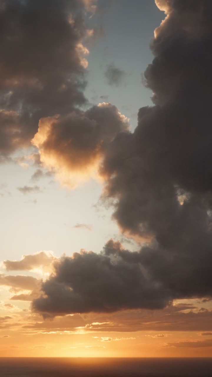 Vertical upward shot of clouds during sunset. The camera pans upward, following a cloud against a dramatic sky