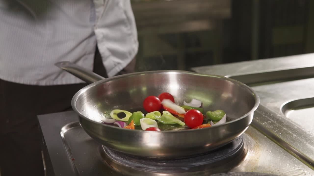 요리사 가 판 에 채소 를 조리 하고 있다