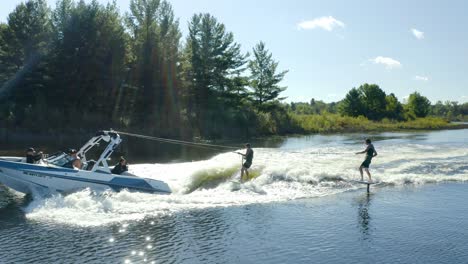 2 wake surfers behind a boat on a lake in michigan