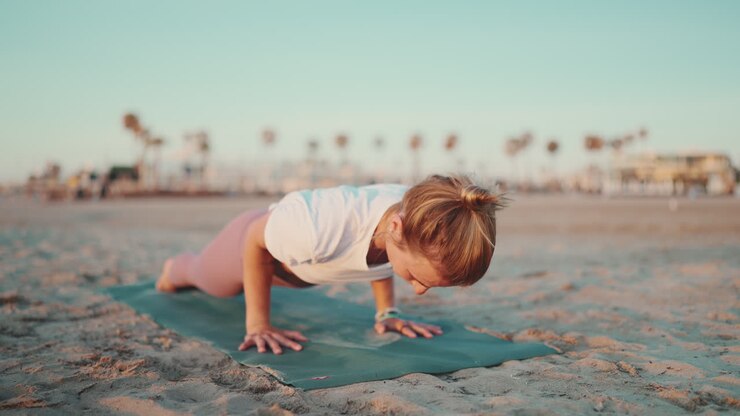 Donna sportiva che si allena su un tappetino da yoga all'aperto