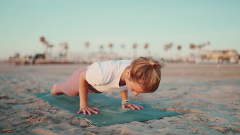 Sporty-woman-exercising-on-yoga-mat-outdoors.