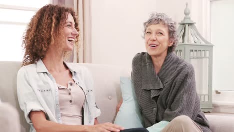 Lächelnde-Frauen-Reden-Auf-Der-Couch-Sitzend