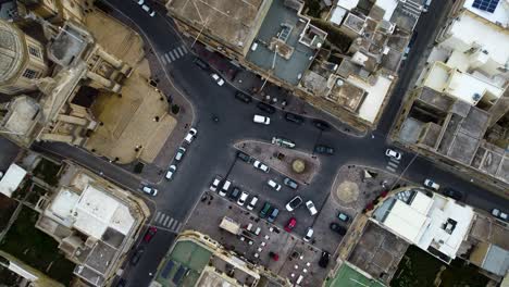 Top-down-birds-eye-view-of-old-town-in-Malta-with-cars-driving-on-the-streets-below