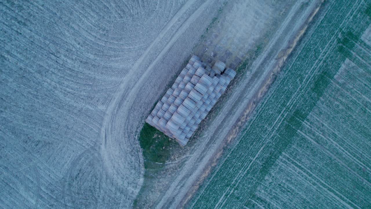 las balas de heno, apiladas en una pirámide, secas en el campo al atardecer.