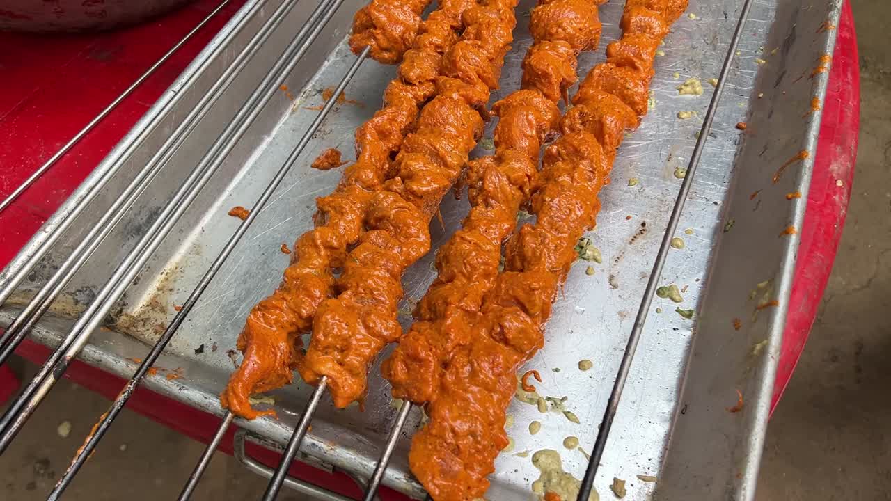 closeup parallax toma de pollo marinado tandoori kebab mantenido para la parrilla en kolkata, india