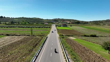 toma real de la carretera rural con una motocicleta circulando por delante