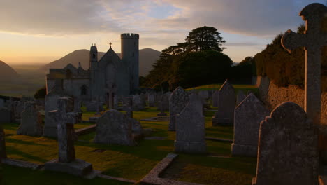 sunset over an ancient church and graveyard in the mountains
