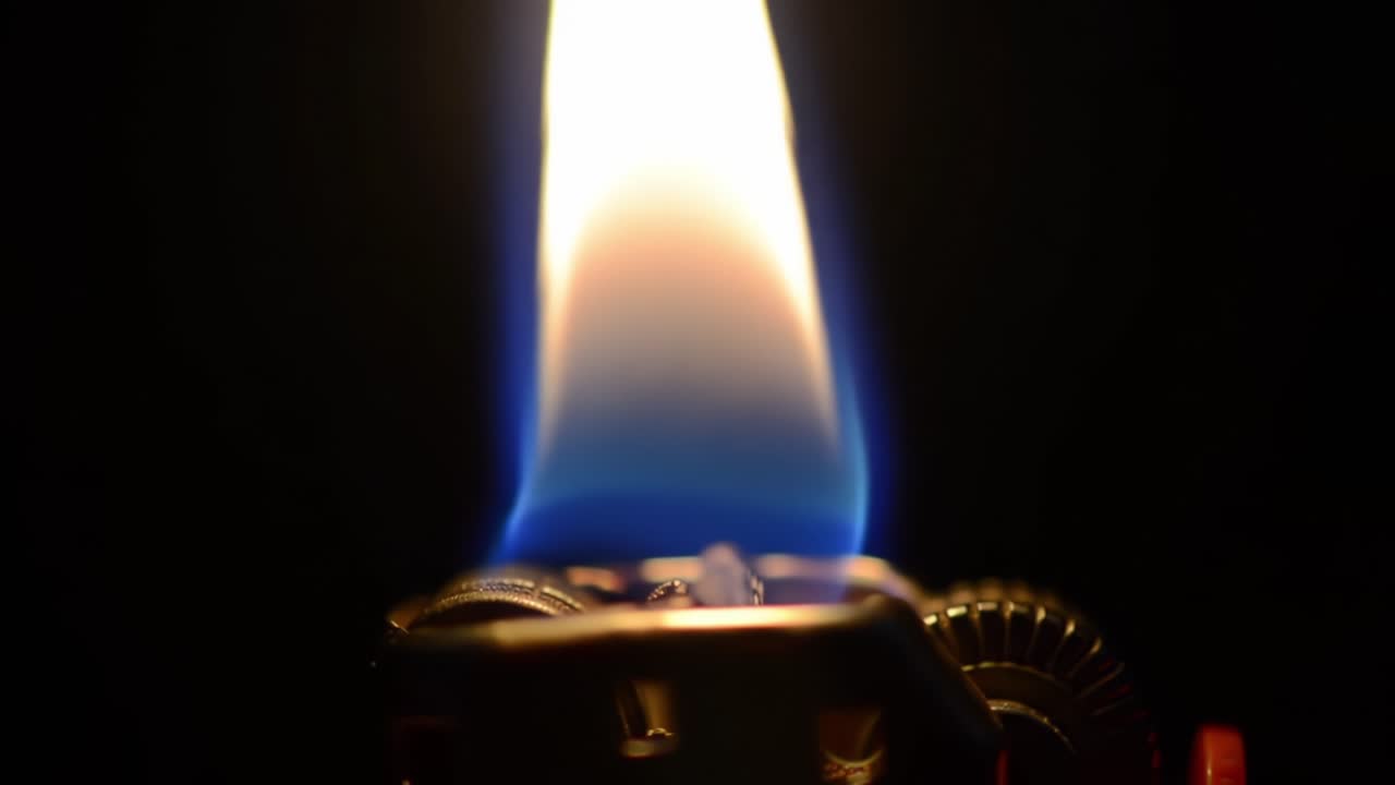 Bright Blue Flame Ignites From Lighter in a Dark Setting Creating a Mesmerizing Visual Effect