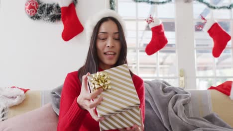 portrait of biracial woman with santa hat having video call