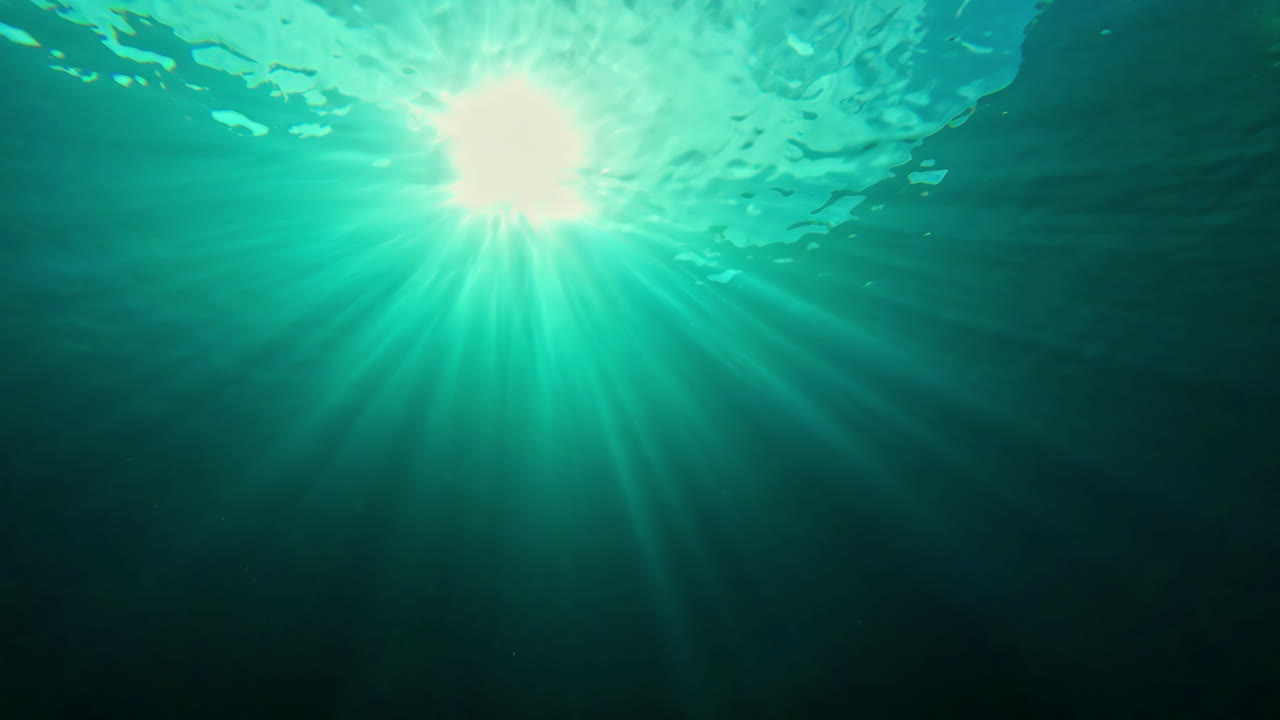 солнечный свет проникает в океанскую воду, вид с дайвера